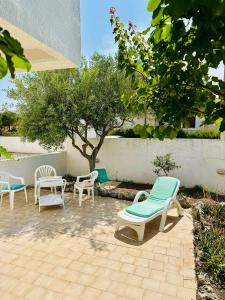 a group of chairs sitting on a patio at Giardino dei Trulli - Villa al Mare in Faccia di Trippa