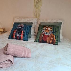 un letto con due cuscini con una tigre sopra di Mercadial au coeur de Saint-Céré a Saint-Céré