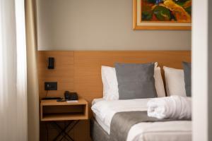 a hotel room with two beds and a telephone at Mona Plaza Zlatibor in Zlatibor