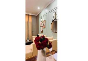 a living room with a couch and a vase with flowers at BluO Awesome 1BHK DLF Galleria Market ,Gym TT in Gurgaon