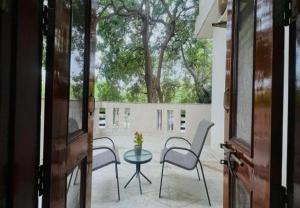 a patio with chairs and a table and a tree at BluO Awesome 1BHK DLF Galleria Market ,Gym TT in Gurgaon