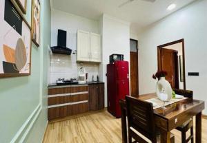 a kitchen with a wooden table and a red refrigerator at BluO Awesome 1BHK DLF Galleria Market ,Gym TT in Gurgaon