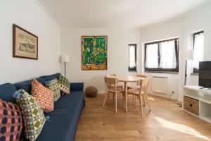 a living room with a blue couch and a table at Cascais Bay in Cascais