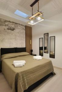 a bedroom with a large bed with two towels on it at Teatro Massimo Terrace relax suite in Palermo +16 photos
