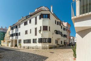 a white building with black windows on a street at Cascais Bay in Cascais