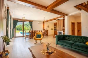 a living room with a green couch and a table at Villa Brusiana with heated pool in Brušane