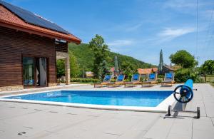 a swimming pool with lounge chairs next to a house at Villa Brusiana with heated pool in Brušane