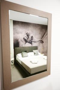 a mirror reflecting a bedroom with two elephants at Soulmade Residence in Cosenza