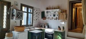 eine Küche mit grünen und weißen Schränken und einer Spüle in der Unterkunft Casablu in Stavrokhórion