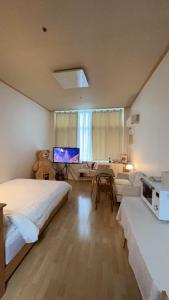 a bedroom with a bed and a desk and a couch at Pyeongchon Gamseong House in Anyang