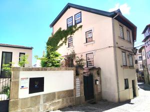 una casa rosa con un cancello in una strada di Casa da Judiaria Velha AP a Viseu