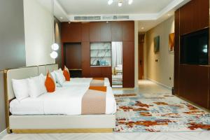 une chambre avec un grand lit avec des oreillers orange dans l'établissement Gerwill Hotel, à Dodoma