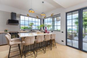 a kitchen with a large island with bar stools at Villa St Hedonist by Villsy in Poljane