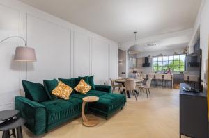 a living room with a green couch and a table at Villa St Hedonist by Villsy in Poljane