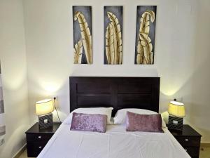 a bedroom with a bed with three pictures on the wall at Villa Azul Mar Menor by Rentalole in Las Casicas +28 photos