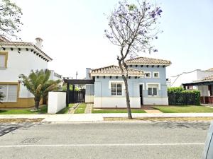 a house with a tree in the middle of a street at Villa Azul Mar Menor by Rentalole in Las Casicas