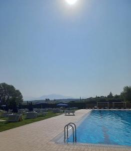 a large swimming pool with the sun in the sky at Life Sport Hotel in Mentana