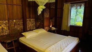 a bedroom with a bed and a window at Muong Dinh Lodge in Ấp Nhơn Bình