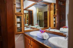 un baño con dos lavabos y dos espejos en Villa Caféière, Bouillante, vue sur mer, proche plage, location Prestige Caraïbes, en Bouillante 81 fotos más
