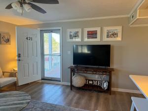 a living room with a flat screen tv next to a door at Lighthouse Village #421 in Ocean City