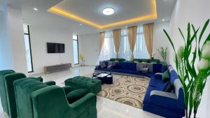 un soggiorno con divani blu e TV a schermo piatto di Luxurious & Spacious Mega Home! ad Addis Abeba