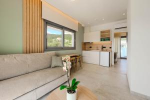 a living room with a couch and a kitchen at Emerald Project in Limenas
