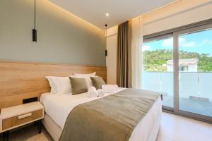 a bedroom with a large bed and a large window at Emerald Project in Limenas +60 photos