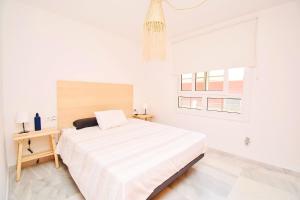 a white bedroom with a large bed and a window at Expoholidays - Galeon 46 Puerto Deportivo in El Ejido