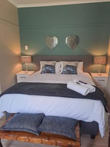 a bedroom with a large bed with two hearts on the wall at Myplekki in Bethlehem