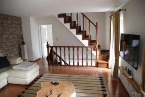 uma sala de estar com um sofá e uma escada em Stone House em Salzedas