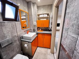 a bathroom with orange cabinets and a sink and a mirror at ZİN D Home Çekmeköy Suit Otel in Istanbul +42 photos
