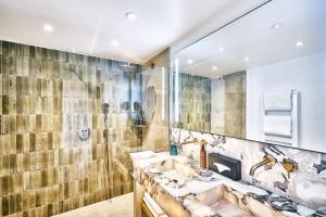 a bathroom with two sinks and a large mirror at La Ferme D'Augustin in Saint-Tropez