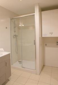 a shower with a glass door in a bathroom at SWEET BCN Plaza Universidad in Barcelona