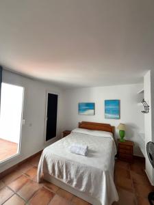 biała sypialnia z łóżkiem i oknem w obiekcie Ático duplex con vistas al mar en Zahara de los Atunes w mieście Zahara de los Atunes +22 zdjęcia