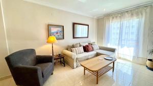 a living room with a couch and a table at SIBS ELPUERTO - SANCIRO Ideal Familias Piscina Parking in El Puerto de Santa María +23 photos