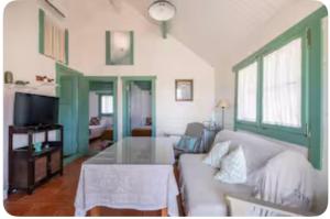 een woonkamer met een bank en een tafel bij La Cabaña de Doñana in El Rocío