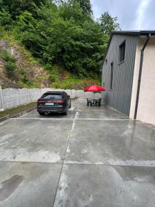 a car parked in a parking lot with a red umbrella at Machakhela Riverhouse in Sindietʼi