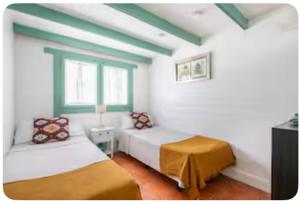 een slaapkamer met twee bedden en een groen en wit plafond bij La Cabaña de Doñana in El Rocío +10 foto's
