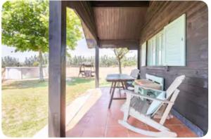 een afgeschermde veranda met een tafel en een bank bij La Cabaña de Doñana in El Rocío