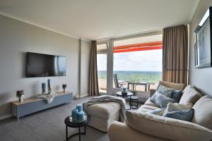 un soggiorno con un divano e una grande finestra di Best View 25th floor, App 331 a Timmendorfer Strand