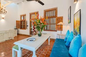 a living room with a white table and blue chairs at Small House Boutique Guest House in Galle