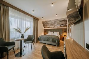 a hotel room with a bed and a table and chairs at Willa Bachledzki Wierch 12 in Zakopane