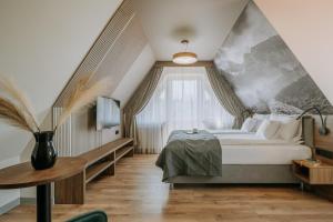 a bedroom with a large bed and a large window at Willa Bachledzki Wierch 12 in Zakopane