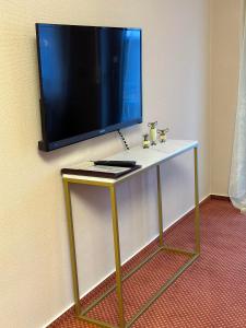 a tv on a wall with a table with a television on it at Lesura Ferien- Apartment in Lieser
