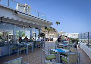 a restaurant with tables and chairs on a patio at Holiday Club Puerto Calma in Puerto Rico de Gran Canaria