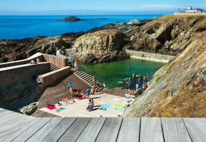 a group of people in the water at a beach at Hotel El Panorama in Tapia de Casariego