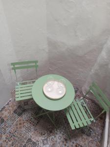 a green table with two chairs and a plate on it at AL-Andalus in Elvas +7 photos