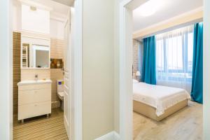 ein Schlafzimmer mit einem Bett, einem Waschbecken und einem Spiegel in der Unterkunft Cartagena Pen Mamaia NORD in Mamaia Nord – Năvodari