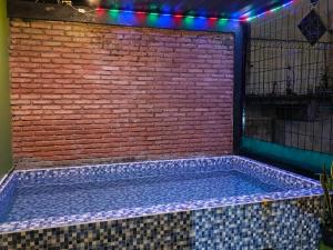 a hot tub in a brick wall with lights at Samara homestay in Mantaak