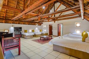 een grote slaapkamer met 2 bedden en een woonkamer bij Amani Lodge - Villa 81 in Warmbaths +62 foto's